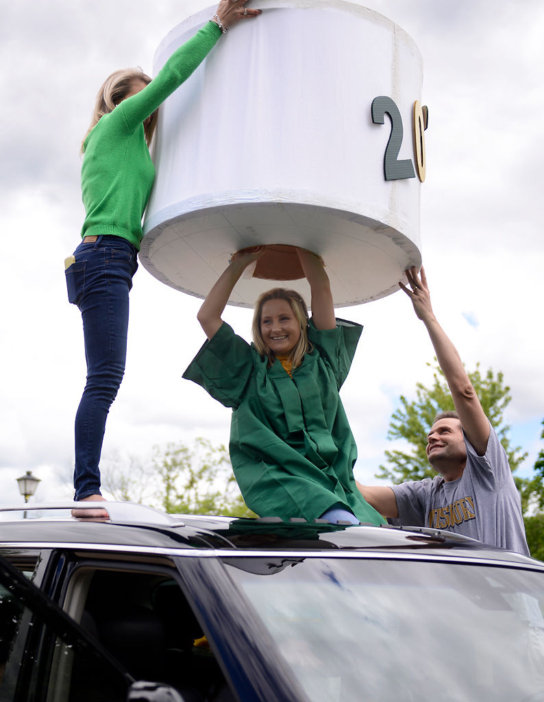Stacey Noble and Brad Noble help their daughter exit from an oversized toilet paper roll